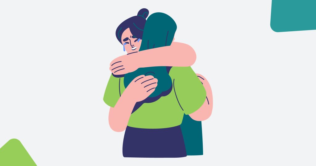 Ilustración de una pareja de mujeres abrazándose mientras una llora, para hablar de cómo superar un duelo.